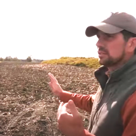 Man in field speaking